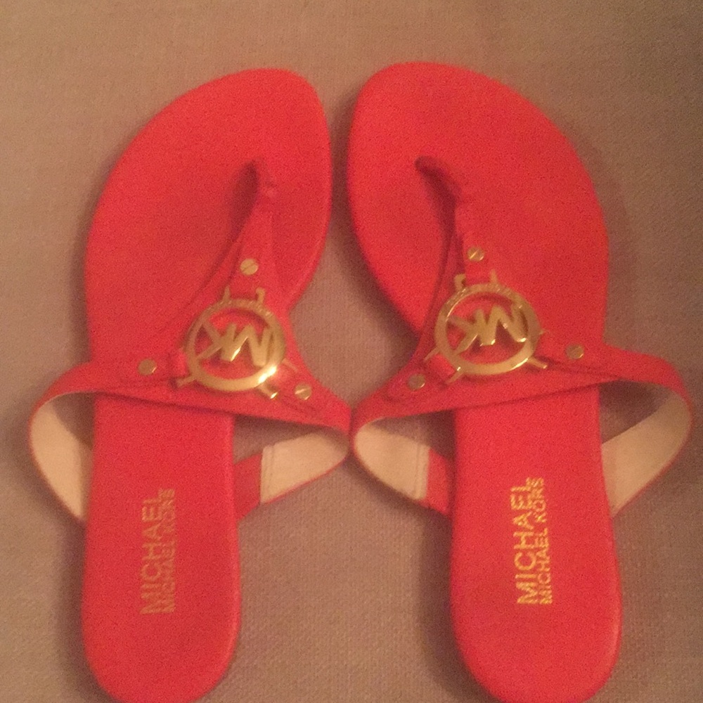 Michael Kors orange-red flip flops.